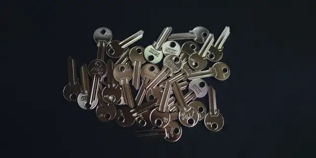 A pile of keys on a dark background.